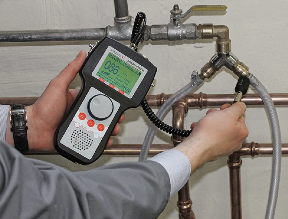 Plumber testing pipes with electronic leak detection equipment in Orlando