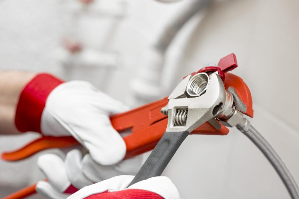 Plumber holding pipe wrenches for an emergency repair in Orlando