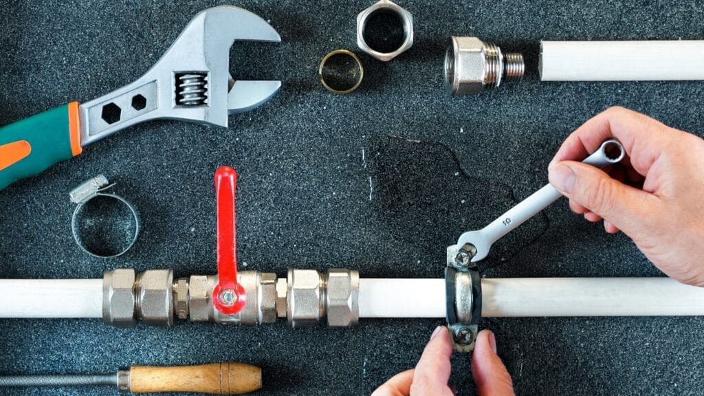 Plumber repairing a pipe valve with an adjustable wrench in Orlando