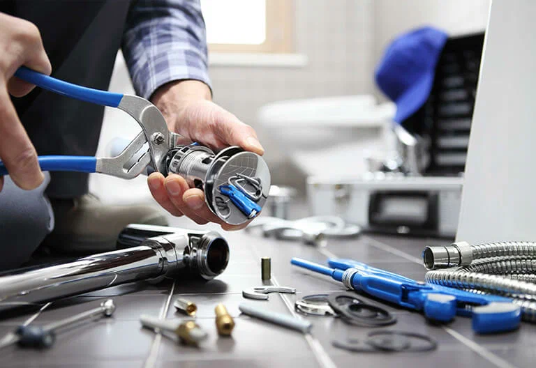 Technician repairing a plumbing fixture with professional tools in Orlando
