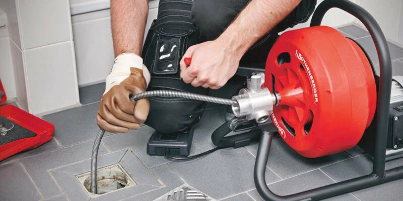 Plumber using a drain-cleaning machine in Orlando