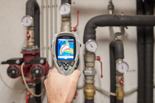 Plumber using a thermal imaging camera to inspect pipes in Orlando