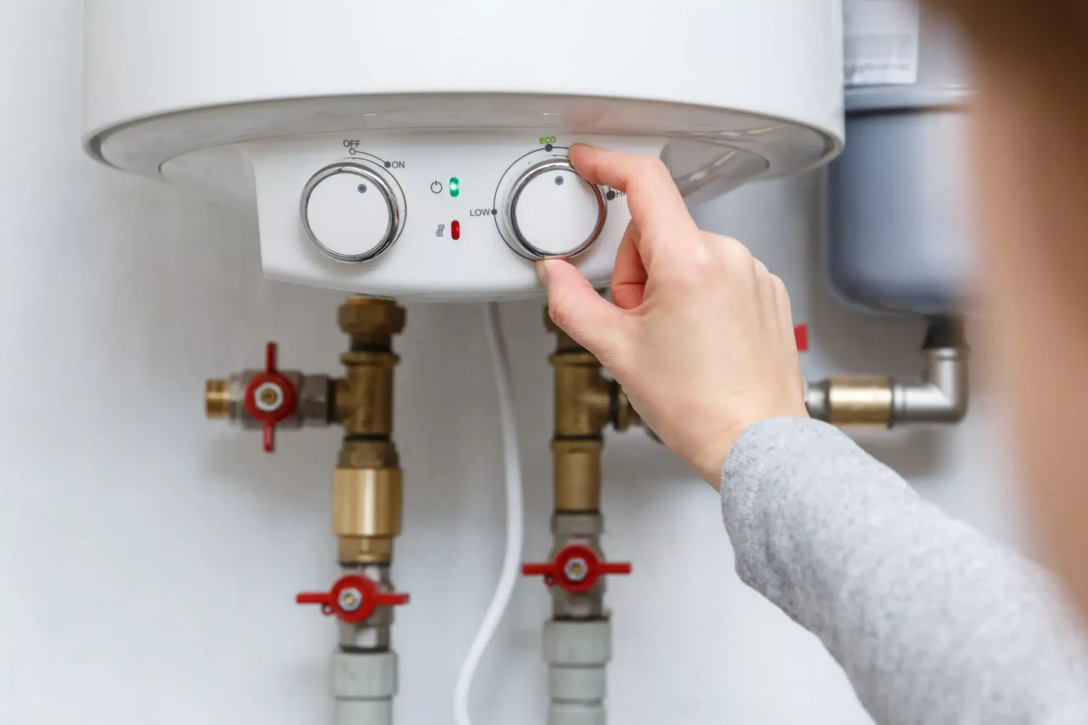 Homeowner adjusting the temperature controls on a water heater in Orlando